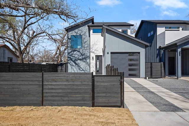 view of front of home featuring board and batten siding, a gate, fence, and a garage