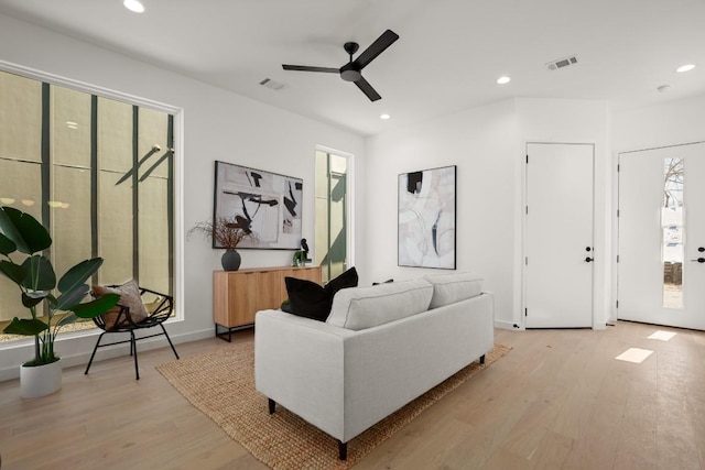 living room with light wood finished floors, visible vents, and recessed lighting