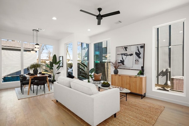 living room with light wood-style floors, visible vents, and recessed lighting