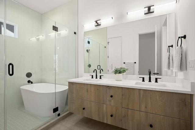 bathroom with a sink, a shower stall, a freestanding bath, and double vanity