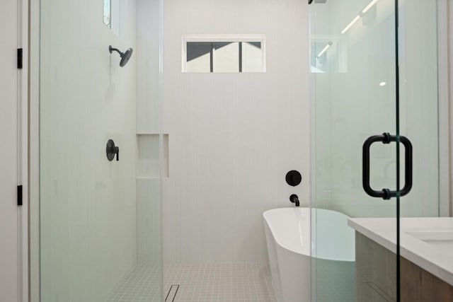 full bathroom featuring a freestanding tub, a shower stall, and vanity