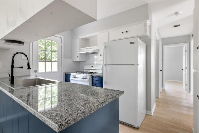 kitchen featuring white appliances, decorative backsplash, under cabinet range hood, open shelves, and a sink