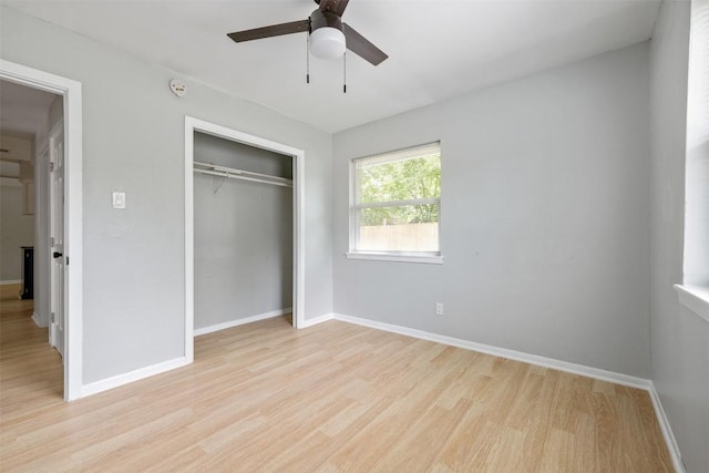 unfurnished bedroom with a closet, ceiling fan, light wood-style flooring, and baseboards