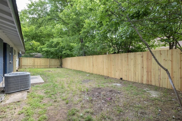 view of yard featuring a fenced backyard and central AC
