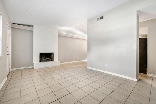 unfurnished living room with light tile patterned flooring, a fireplace, visible vents, and baseboards