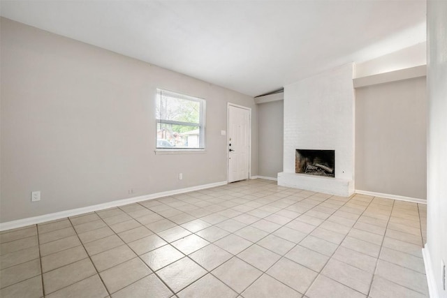 unfurnished living room featuring a fireplace, baseboards, and light tile patterned floors