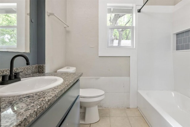 full bath with toilet, tile patterned floors,  shower combination, vanity, and tile walls