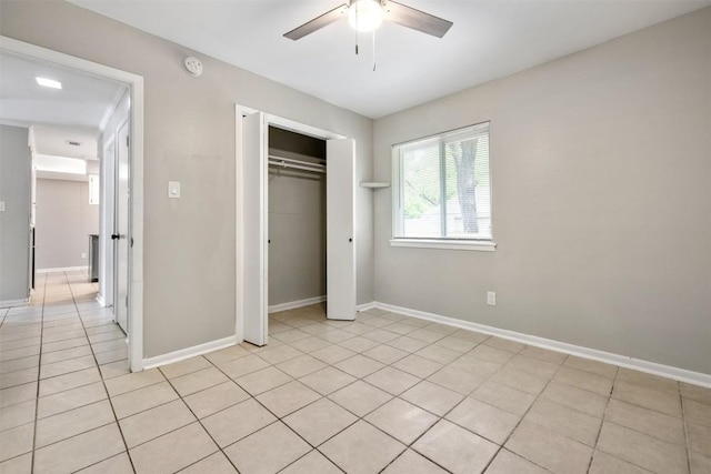 unfurnished bedroom with a closet, ceiling fan, baseboards, and light tile patterned floors