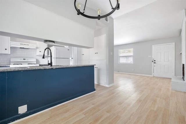 kitchen with white appliances, decorative backsplash, light wood-style floors, blue cabinetry, and under cabinet range hood