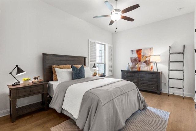 bedroom featuring ceiling fan, light wood finished floors, and baseboards