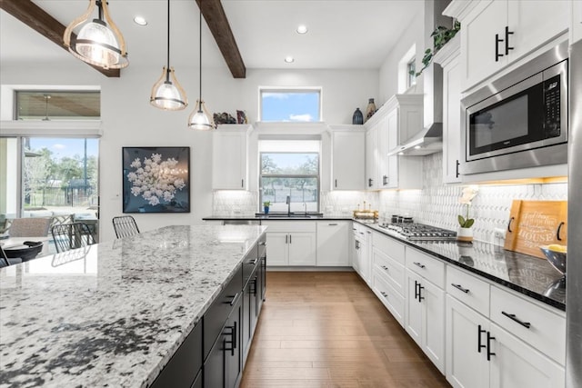 kitchen featuring dark stone counters, appliances with stainless steel finishes, white cabinetry, and tasteful backsplash