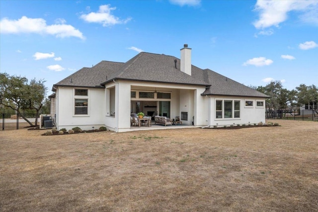 rear view of house with a patio, a chimney, an outdoor hangout area, fence, and a yard