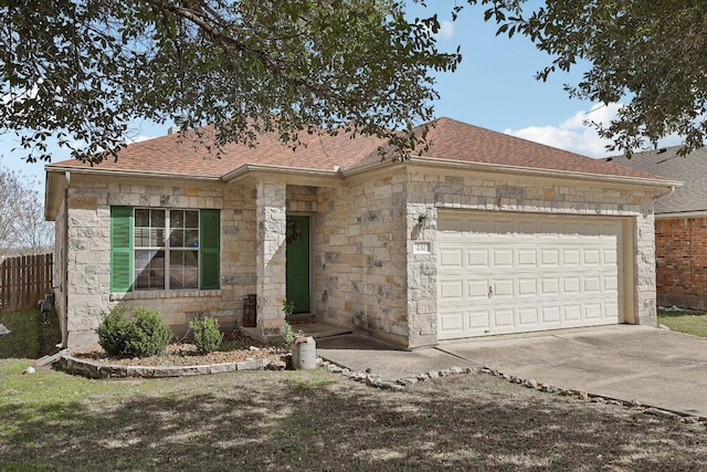 ranch-style home with a garage, a shingled roof, concrete driveway, stone siding, and fence