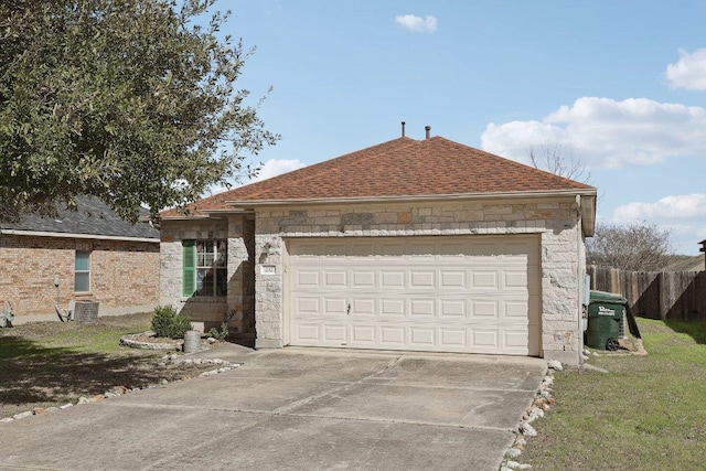 ranch-style house with an attached garage, fence, concrete driveway, stone siding, and roof with shingles