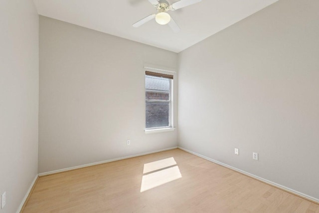 spare room with ceiling fan, light wood-style flooring, and baseboards