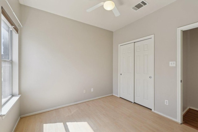 unfurnished bedroom with light wood finished floors, multiple windows, and visible vents