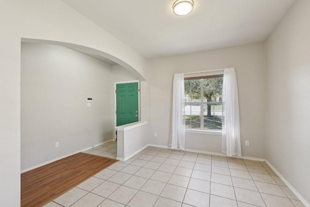 spare room with light tile patterned flooring and baseboards