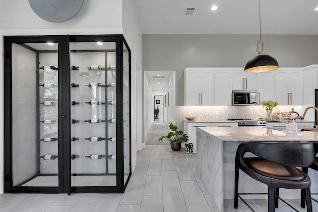 711 Twin Sails, Horseshoe Bay, TX 78657 - kitchen with tasteful backsplash, stainless steel microwave, visible vents, stove, and white cabinets