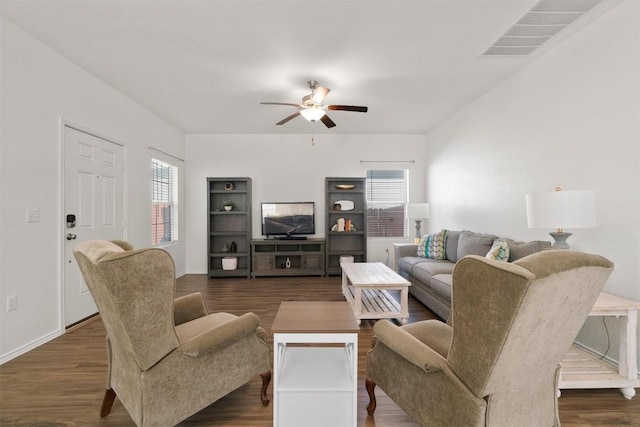 living room featuring dark wood-style floors, baseboards, visible vents, and a ceiling fan