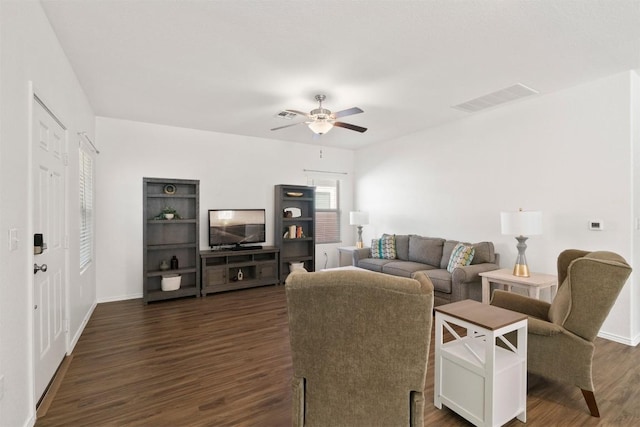 living room featuring ceiling fan, dark wood-type flooring, visible vents, and baseboards