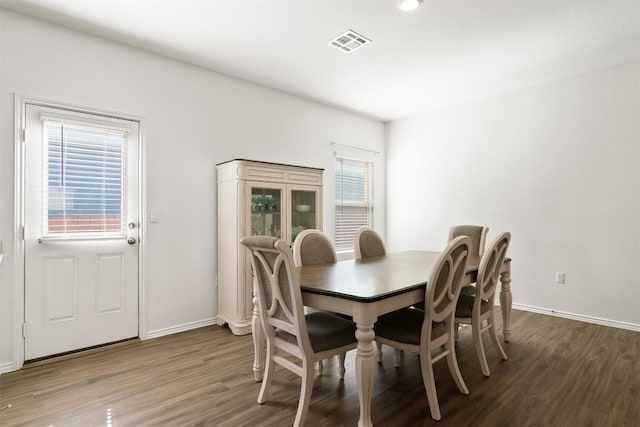 dining space with a healthy amount of sunlight, visible vents, baseboards, and wood finished floors