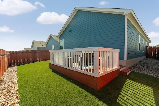 exterior space with a fenced backyard, a lawn, and a wooden deck