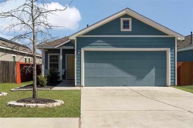 view of front of home with a front yard, fence, driveway, and an attached garage