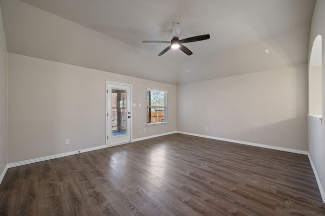 empty room with lofted ceiling, dark wood-style flooring, ceiling fan, and baseboards