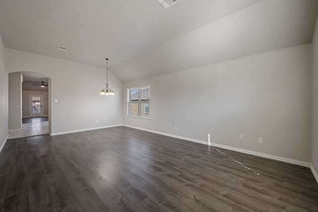 unfurnished room with arched walkways, ceiling fan with notable chandelier, dark wood-type flooring, visible vents, and vaulted ceiling