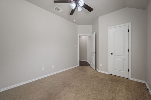 unfurnished bedroom featuring lofted ceiling, baseboards, visible vents, and carpet flooring