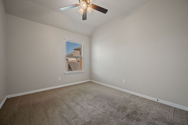 spare room with vaulted ceiling, carpet flooring, a ceiling fan, and baseboards