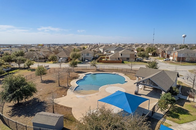 community pool featuring a fenced backyard, a residential view, and a patio