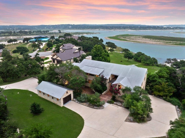 aerial view at dusk featuring a water view