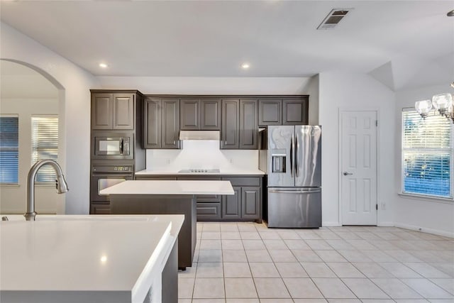 kitchen with light countertops, visible vents, a healthy amount of sunlight, under cabinet range hood, and black appliances