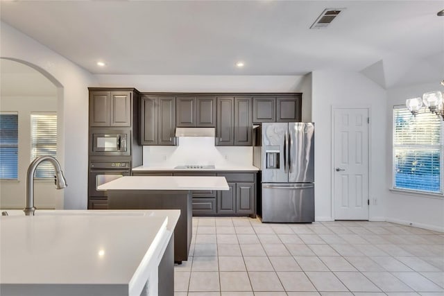 2916 Chisholm Trl, Austin, TX 78734 - kitchen with stainless steel fridge with ice dispenser, oven, arched walkways, light countertops, and built in microwave