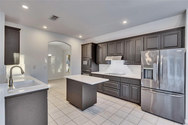 kitchen with arched walkways, visible vents, a sink, under cabinet range hood, and black appliances