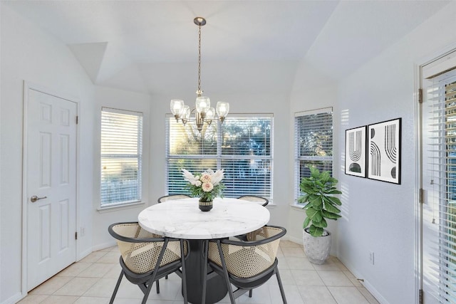 dining area with vaulted ceiling, light tile patterned floors, baseboards, and an inviting chandelier