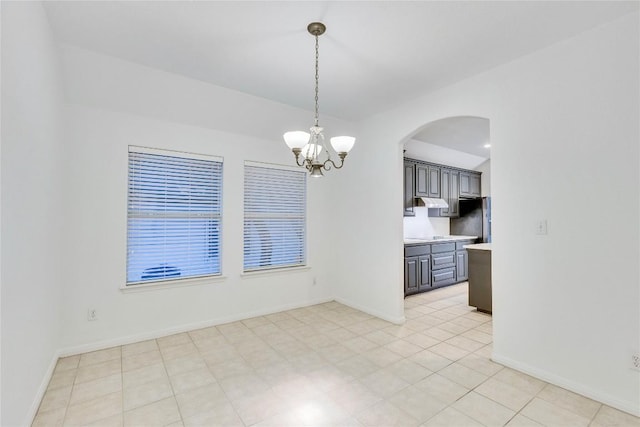 interior space with an inviting chandelier, baseboards, and arched walkways