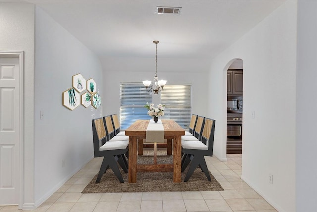 dining space featuring baseboards, visible vents, arched walkways, an inviting chandelier, and light tile patterned flooring