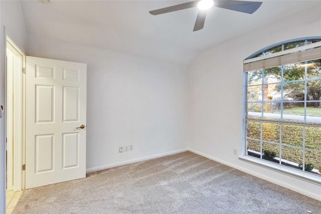 carpeted empty room with ceiling fan, baseboards, and vaulted ceiling