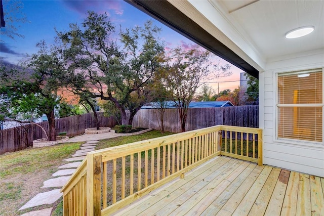 wooden terrace with a fenced backyard