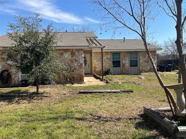 view of front facade featuring stone siding and a front lawn