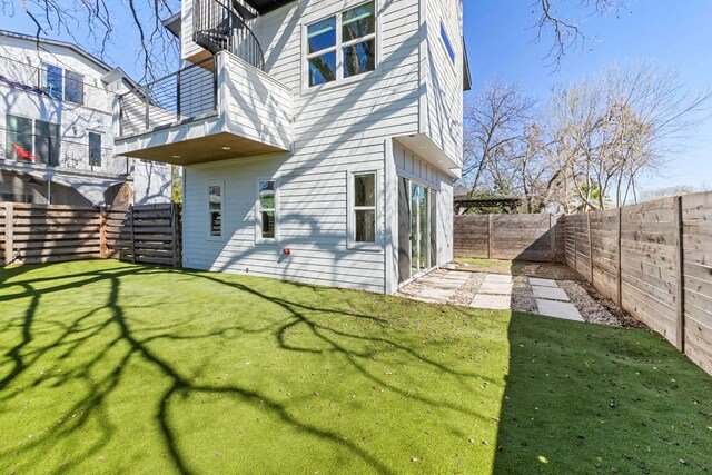 back of property featuring a fenced backyard and a yard