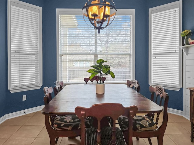 dining space with baseboards, a chandelier, and tile patterned floors