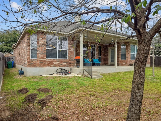 rear view of house featuring a yard, a fenced backyard, and brick siding