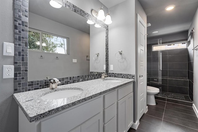 bathroom featuring a shower stall, a sink, toilet, and tile patterned floors