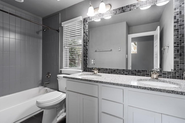 bathroom featuring double vanity, tub / shower combination, a sink, and toilet