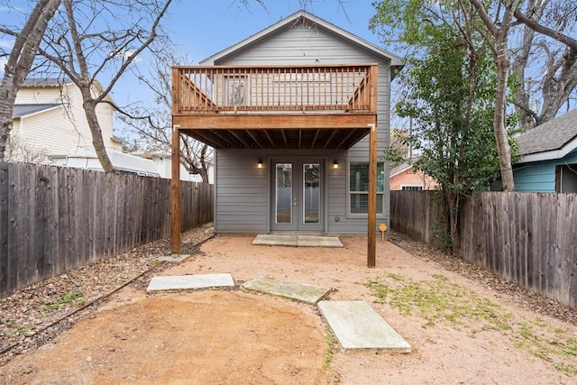 back of property with french doors and a fenced backyard