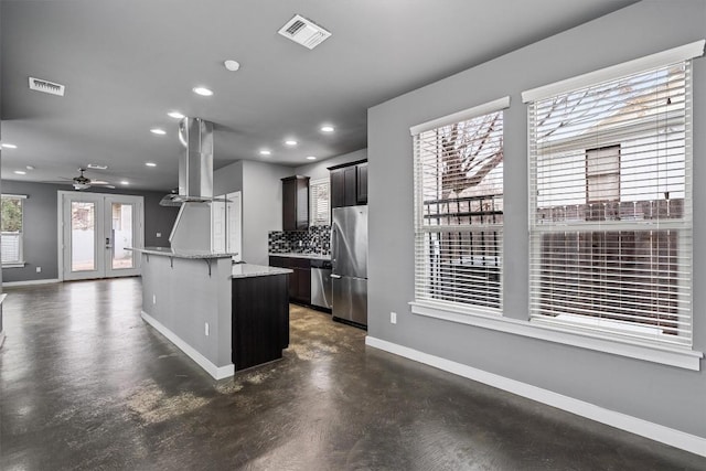 kitchen featuring appliances with stainless steel finishes, visible vents, baseboards, and extractor fan