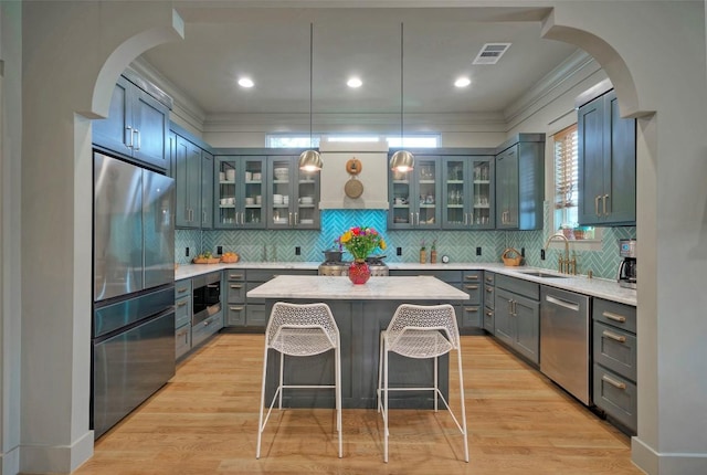 kitchen featuring arched walkways, visible vents, stainless steel appliances, and a sink